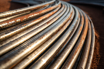 Stack of pipeline of tubing pipe in dirty condition that used in the oil production industrial. Close-up and selective at the object.