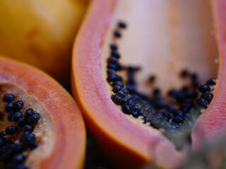 Papaya fruit and papaya seeds on the straw background.