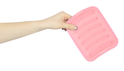 silicone mold for cooking sausages in hand, outstretched hand with silicone mold isolated from background