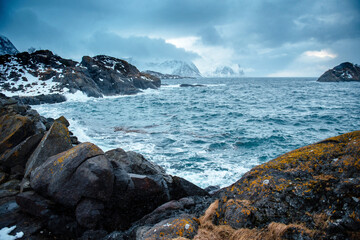 Dramatic Seascape with Rocky Coastline and Snowy Mountains
