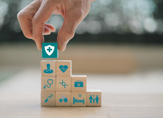 Hand holding wooden blocks, health insurance concept, medical wooden blocks with icons, health and access to health benefits concept