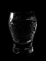 Close-up of sparkling water in an intricate crystal glass on black background