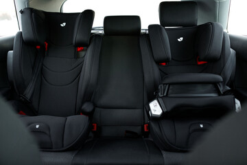 two black safety seats for children in the back of a car