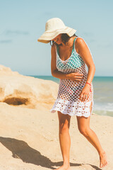 A Latina woman laughing on a beach afternoon in a crochet dress