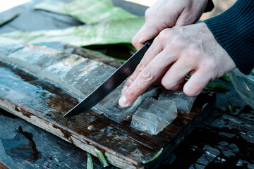 man cutting some pieces of aloe gel