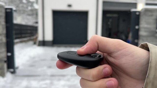An individual skillfully operates a remote control in snowy weather conditions next to open gate