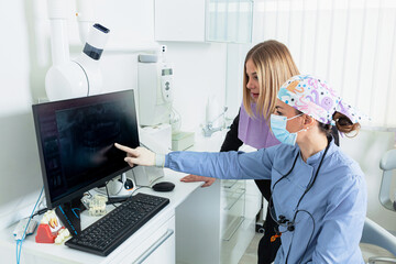 Dentist showing teeth x ray to patient in dental clinic