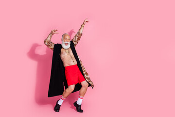Fototapeta premium Full size photo of eccentric aged man leopard bathrobe dancing empty space isolated on pink color background