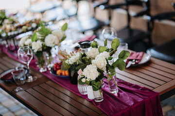 Luxurious dining table setup with flowers, appetizers, and wine glasses for an elegant celebration