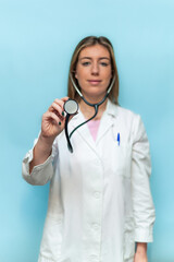 vertical Doctor woman holding a stethoscope on blue background