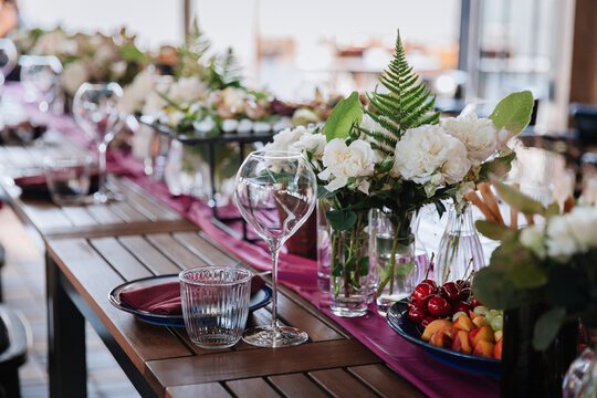 Luxurious dining table setup with flowers, appetizers, and wine glasses for an elegant celebration
