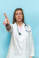 Fototapeta premium vertical Serious doctor woman making a stop sign with her hand