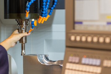 The operator changing the rough cutting tool on CNC milling machine.