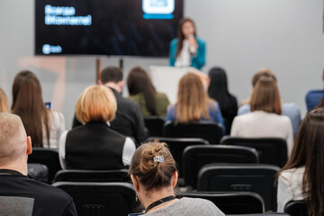 Conference attendees focused on speaker giving presentation during business event in meeting room