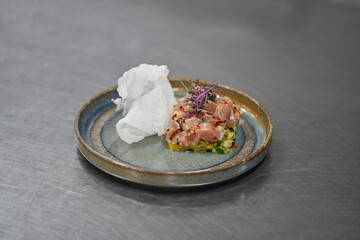 A gourmet dish featuring fresh tuna tartare with exotic mango and avocado, beautifully plated in a modern culinary style