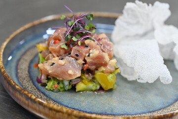 A gourmet dish featuring fresh tuna tartare with exotic mango and avocado, beautifully plated in a modern culinary style