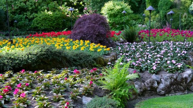 Victoria British Columbia, Canada Butchart Gardens National Historic Site of Canada, the Butchart Gardens, with tourists looking at the sights walking around paths in the Sunken Gardens.