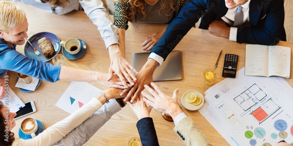 Poster Diverse team collaboration, hands together over a table. Teamwork, unity, and collaboration emphasized. Office setting with diverse team, unity in focus. Business people in teamwork stacking hands.