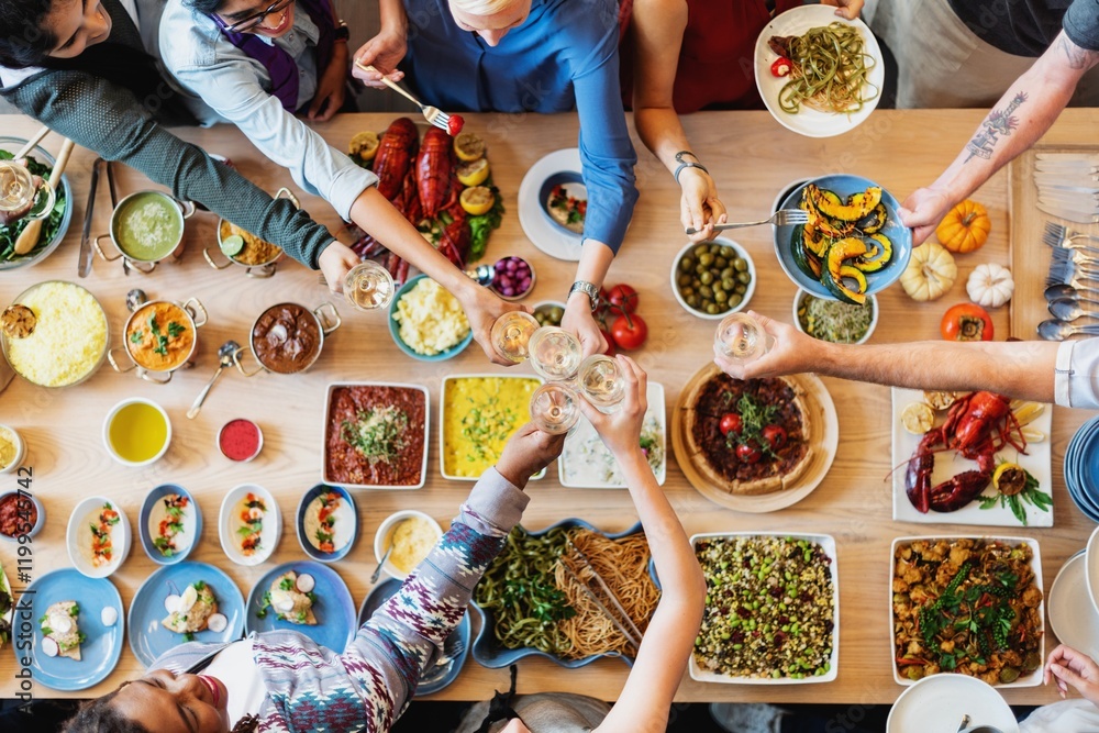 Poster a diverse group enjoying a meal together, sharing food and drinks. top view of a table with various 