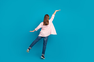 Cute young girl posing on a vibrant blue background, showcasing a stylish casual outfit with charming personality