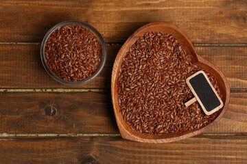 heart shaped bowl with flax seeds on wooden background