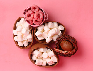 chocolate egg with marshmallow on pink background