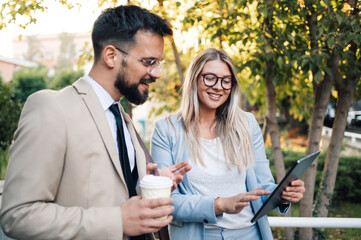 Business people having informal meeting using tablet and drinking coffee