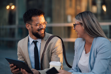 Fototapeta premium Business people having fun using digital tablet outdoors after work