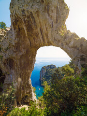 Fototapeta premium Natural arch on Capri, Italy, with stunning view of Mediterranean sea and surrounding greenery