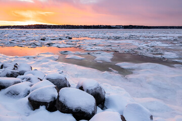 Winter colourful sunrise view of the St. Lawrence River partly covered in ice with the south shore in the background, Cap-Rouge area, Quebec City, Quebec, Canada