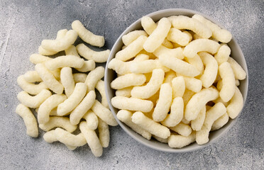 Air corn sticks in a ceramic plate on a gray background.