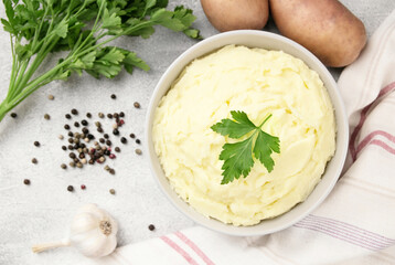 Mashed potatoes in white bowl on grey concrete background. Healt