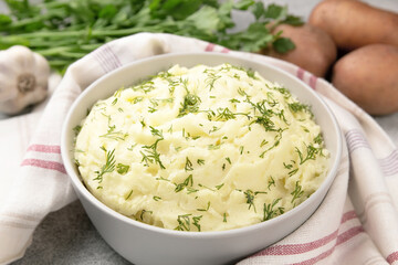 Mashed potatoes in white bowl on grey concrete background. Healthy food