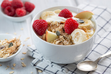 Healthy breakfast, muesli with raspberries, yogurt and cereals