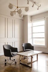 Modern office with two gray chairs, a white marble table, and a stylish chandelier. The office features gray chairs, a marble table, and a chandelier in a bright space. Aesthetic room decor in office.