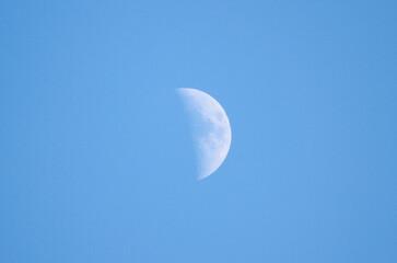 A beautiful crescent moon shines brightly in a clear blue sky