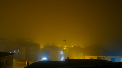 A city immersed in the night, filled with a lot of fog and glowing lights