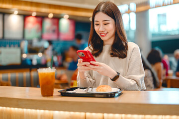 Adult asian woman eating food meal at indoors cafeteria airport terminal