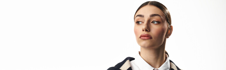 A young, beautiful woman showcases her emotions while posing in a bright studio environment.