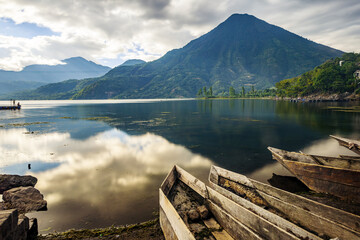 View of the lake and the volcano on a summer day with wooden canoes on the beach. © SALMONNEGRO