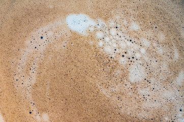 Coffee cream texture of fragrant coffee in a cup with delightful coffee colored bubbles with foam. macro coffee crema