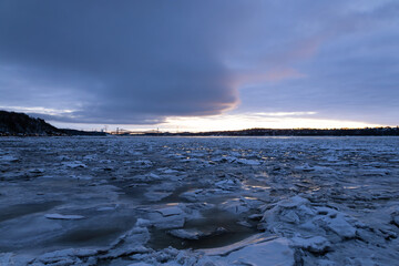 Blue hour winter panoramic view of the St. Lawrence River partly covered in ice, with the Pierre-Laporte and Quebec bridges in the background, Quebec City, Quebec, Canada