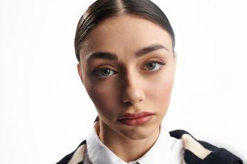 A young beautiful woman reveals deep emotions through her striking gaze in a clean, simple backdrop.