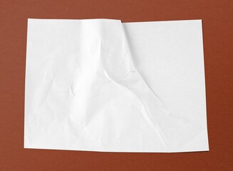 White crinkled paper on brown background