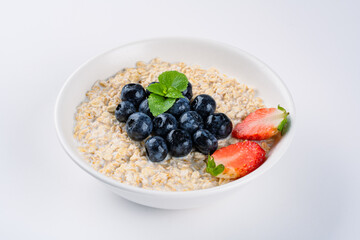 Milk porridge prepared for breakfast with blueberries, strawberries and bananas