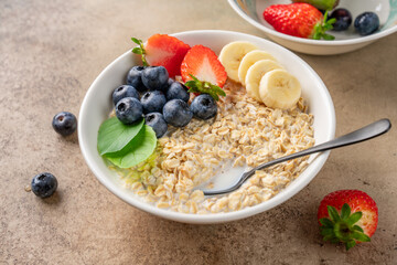 Milk porridge prepared for breakfast with blueberries, strawberries and bananas