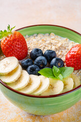 Milk porridge prepared for breakfast with blueberries, strawberries and bananas