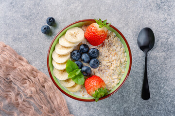 Milk porridge prepared for breakfast with blueberries, strawberries and bananas