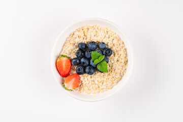Milk porridge prepared for breakfast with blueberries, strawberries and bananas
