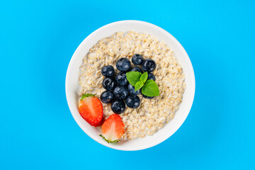 Milk porridge prepared for breakfast with blueberries, strawberries and bananas